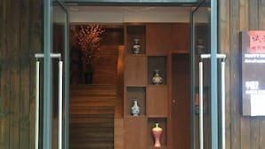 A wooden interior with a staircase, shelves with decorative items, and a sign with text. - OYO Nanchang Happy Waterbed Literature Hotel (Nanchang)