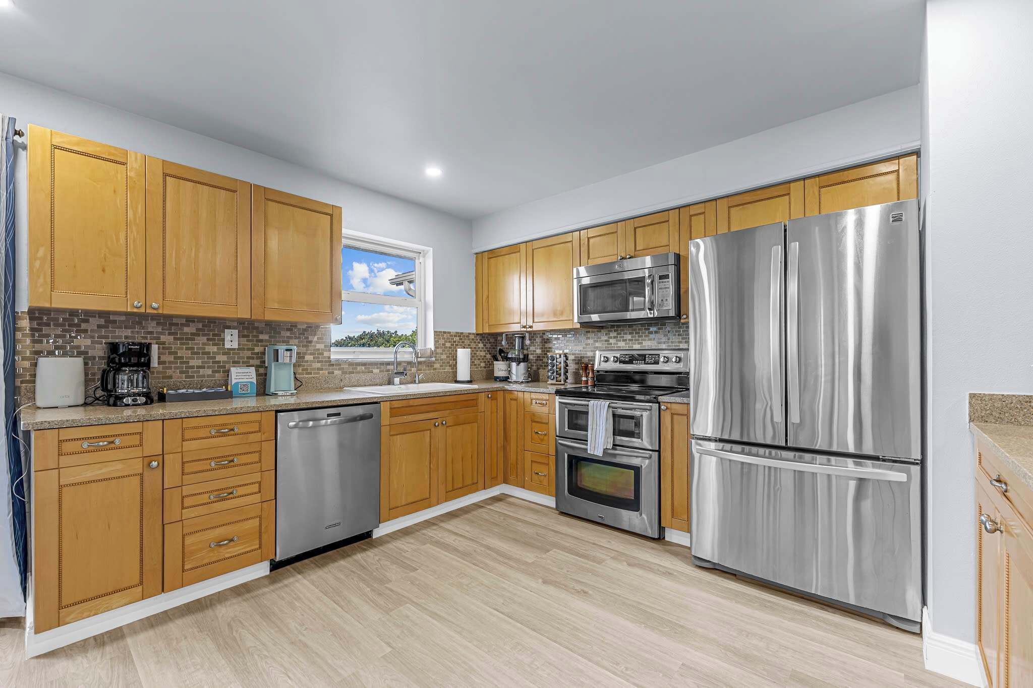 A modern kitchen with wooden cabinets, stainless steel appliances, and a dishwasher.