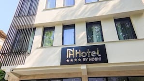 A hotel with a modern facade, large windows, and a sign indicating it is a 4-star establishment.