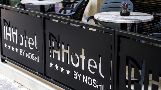 A hotel sign with the name "Hotel by Nosh" and a five-star rating.