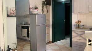 A modern kitchen with a built-in refrigerator, a sink, and a countertop with a plant. - 10 Minutes Walk From San Pietro Excellent for 4 People, Families and Friends (Roma)