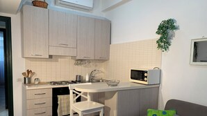 A compact kitchen with a microwave, sink, and a small dining area. - 10 Minutes Walk From San Pietro Excellent for 4 People, Families and Friends (Roma)