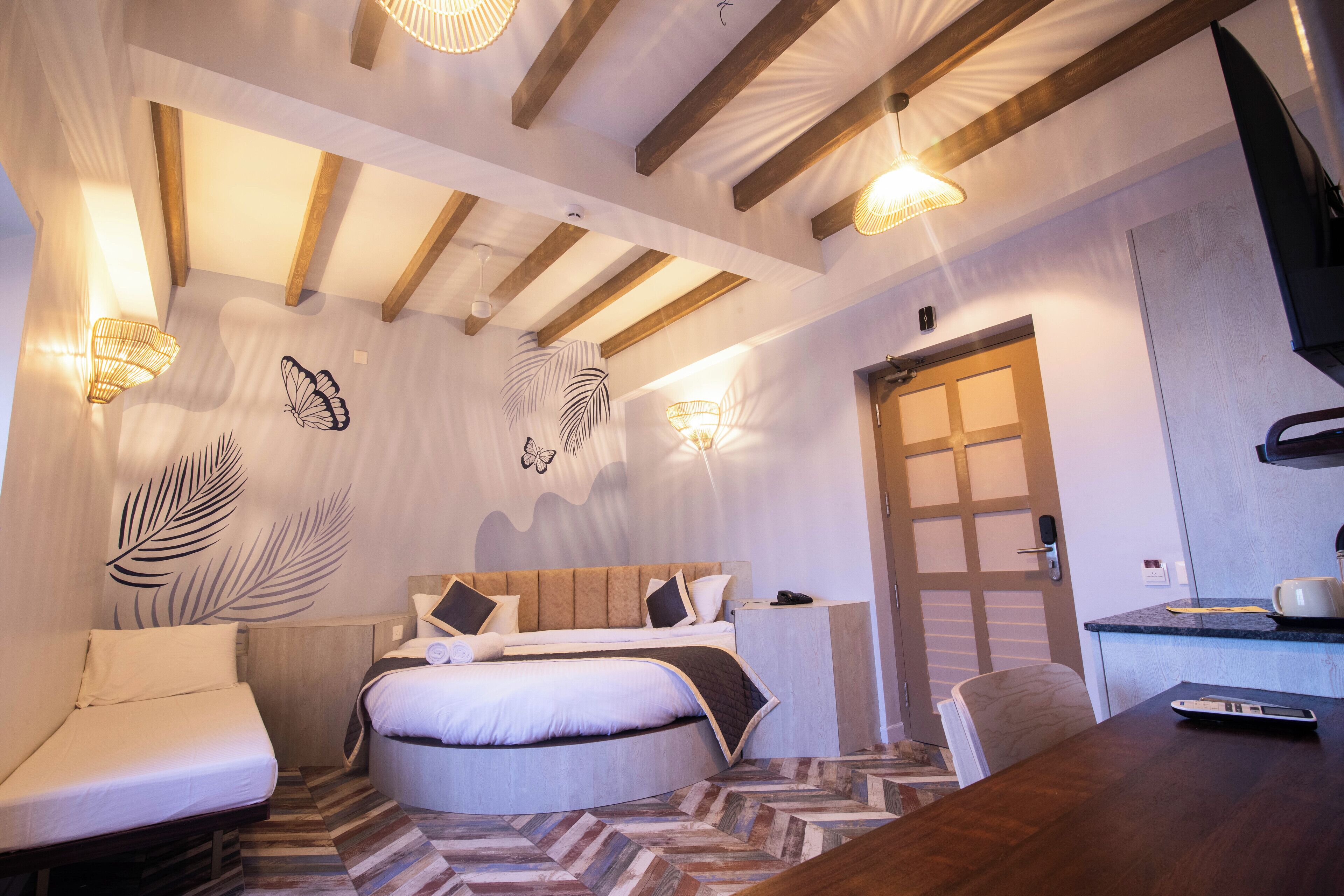 A modern bedroom with a bed, bedside tables, a desk, and a chair.