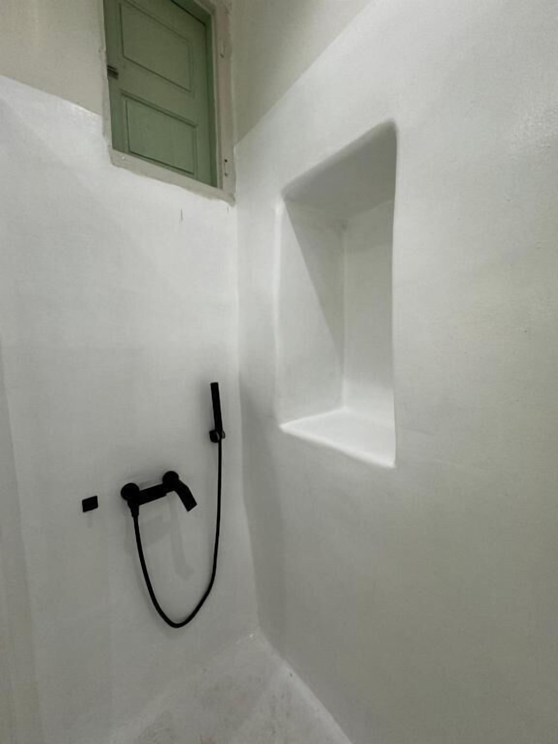 Un baño con ducha, una ventana pequeña y un perchero para toallas.