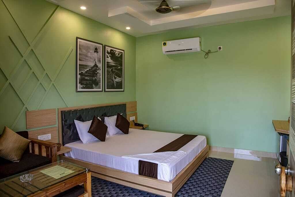 A bedroom with a bed, a nightstand, a wooden bench, and a small table.