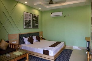 A bedroom with a bed, a nightstand, a wooden bench, and a small table.