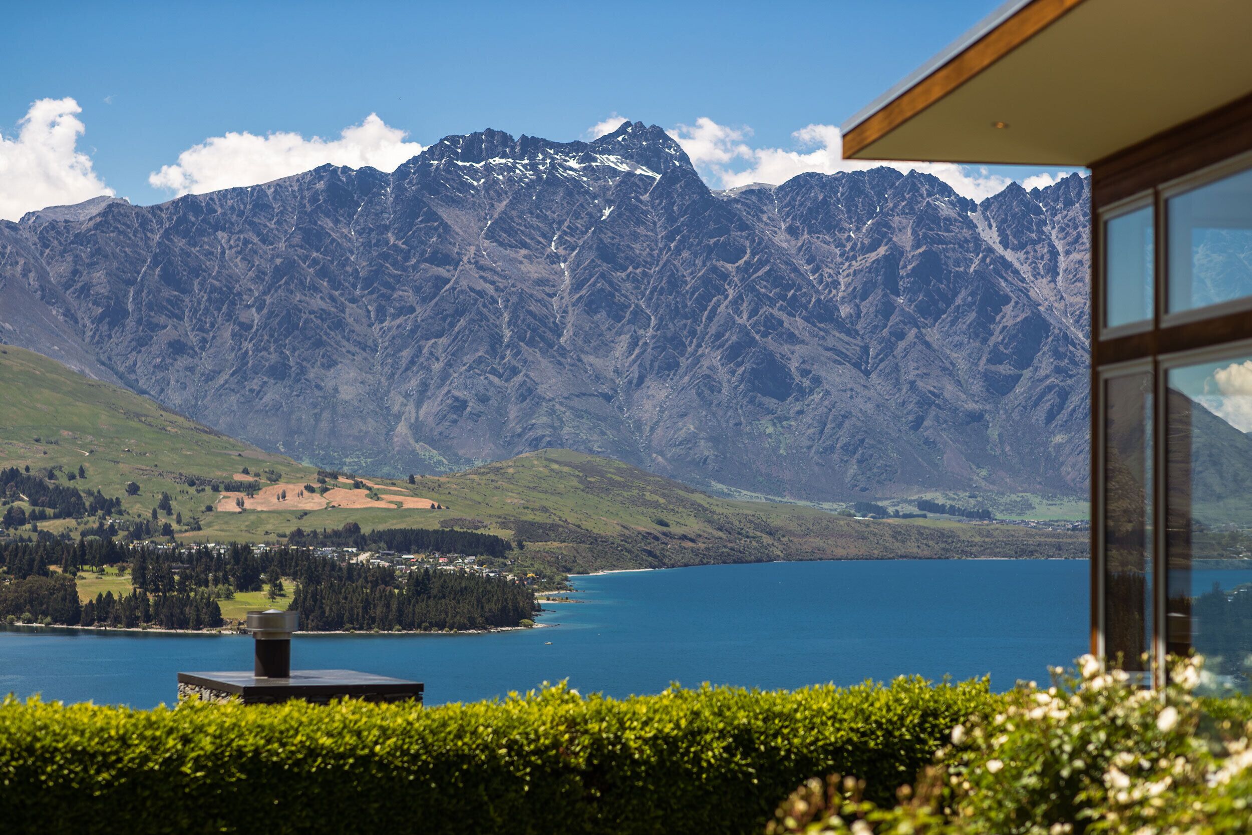 A mountain view with a lake and a building with large windows.