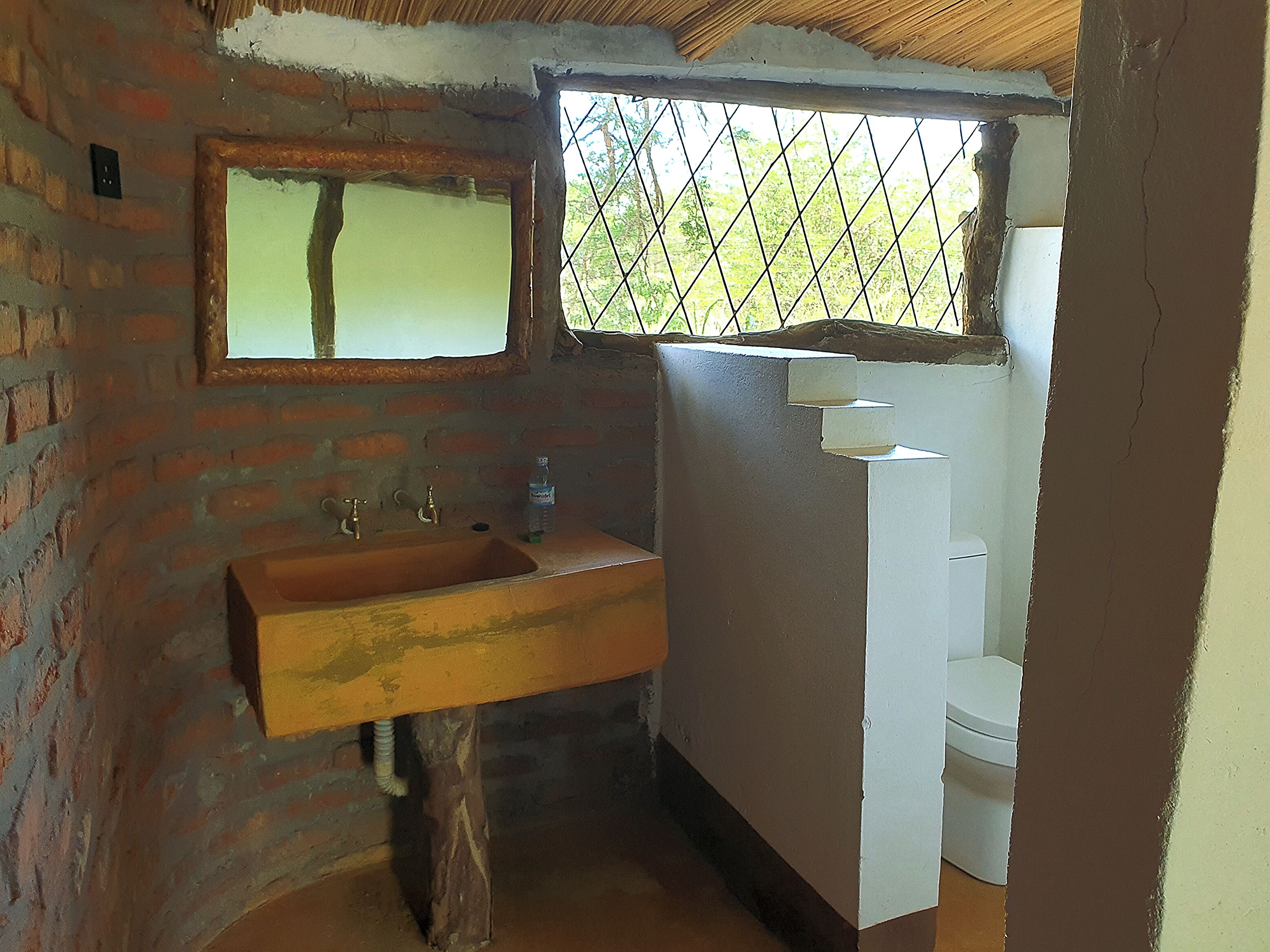 Un baño con lavamanos de madera, un espejo y un inodoro blanco.