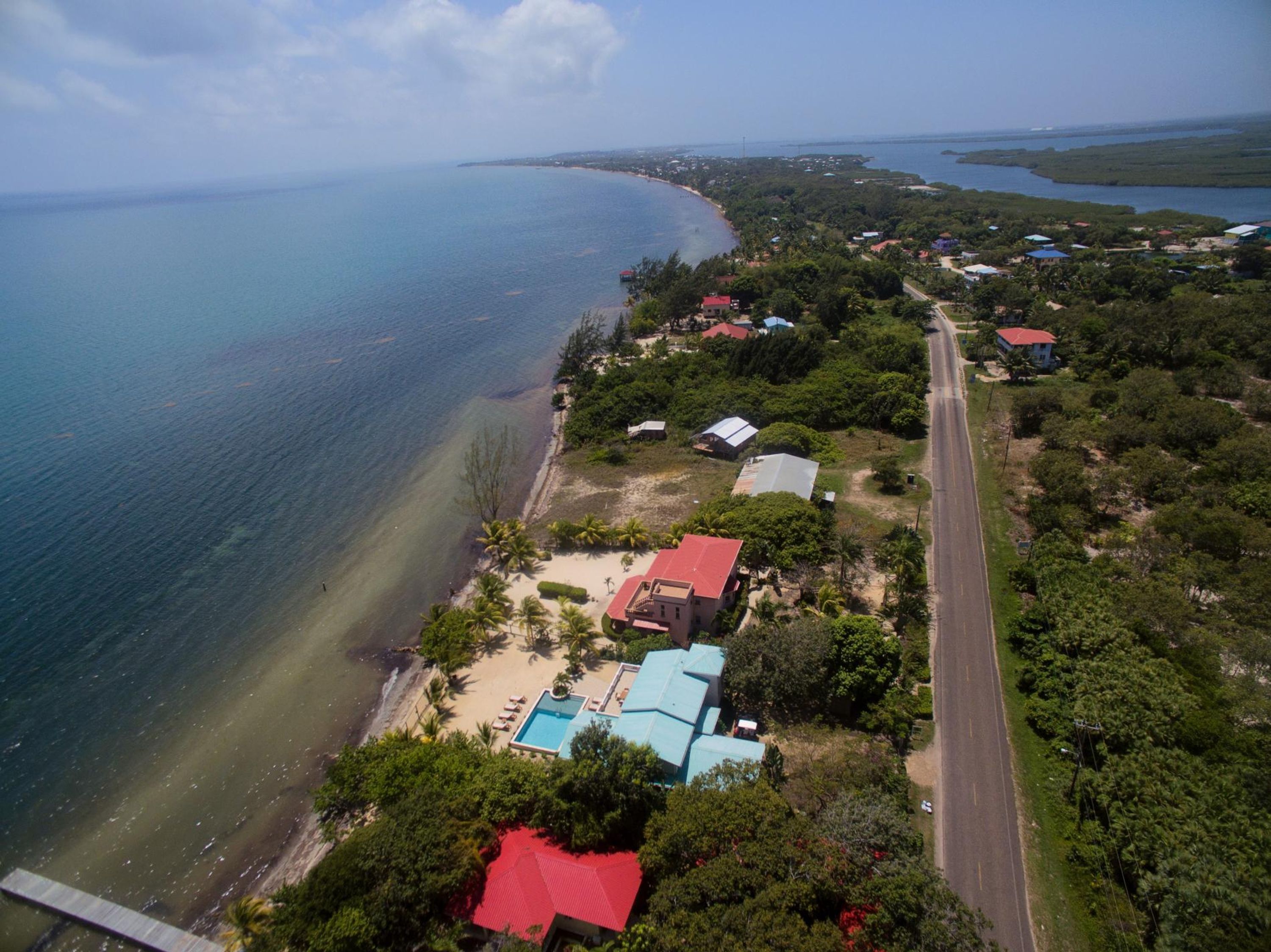Vista aérea de una zona costera con carretera, casas y playa.