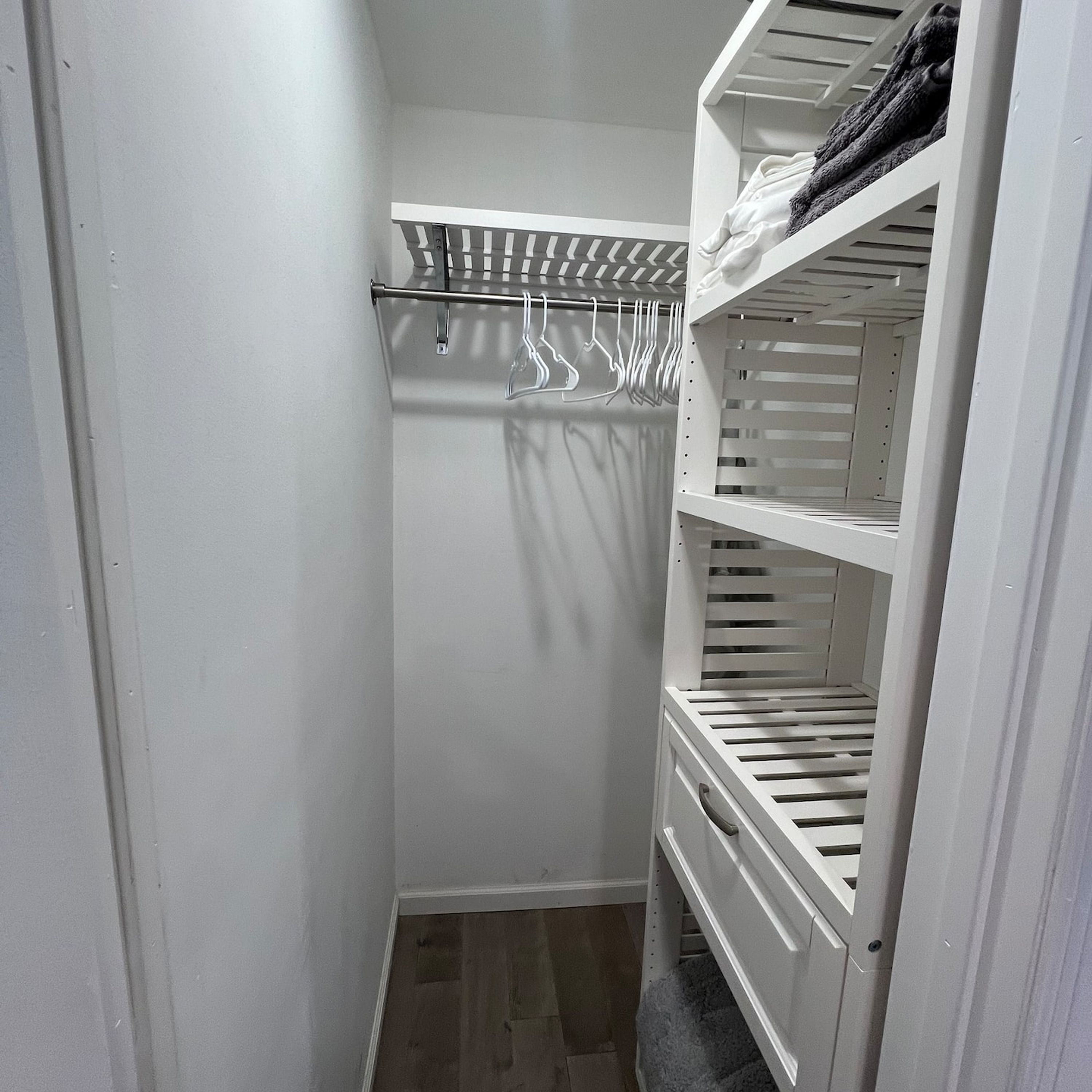 A walk-in closet with a hanging rod and built-in shelves.