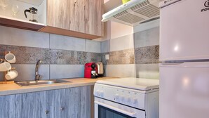 Una cocina moderna con horno integrado, cafetera y pileta.