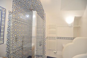 A bathroom with patterned tiles, a shower, and a white radiator. - Art House in Amalfi Historical Center Near Beach (Amalfi)