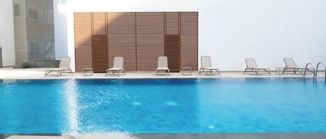 Alberca al aire libre y camastros