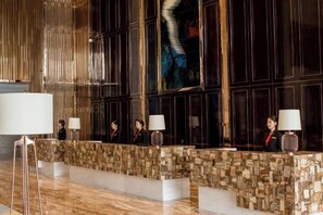 A reception area with a stone-textured counter, large windows, and a modern chandelier. - V · Leader SHENHANG International (Yinchuan)