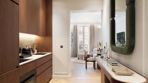A modern kitchen with wooden cabinets, a built-in oven, and a marble countertop. - The Lander - Serviced 2BR/2BA - Opéra I (Paris)