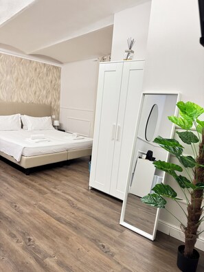 Un dormitorio moderno con cama, armario y espejo.