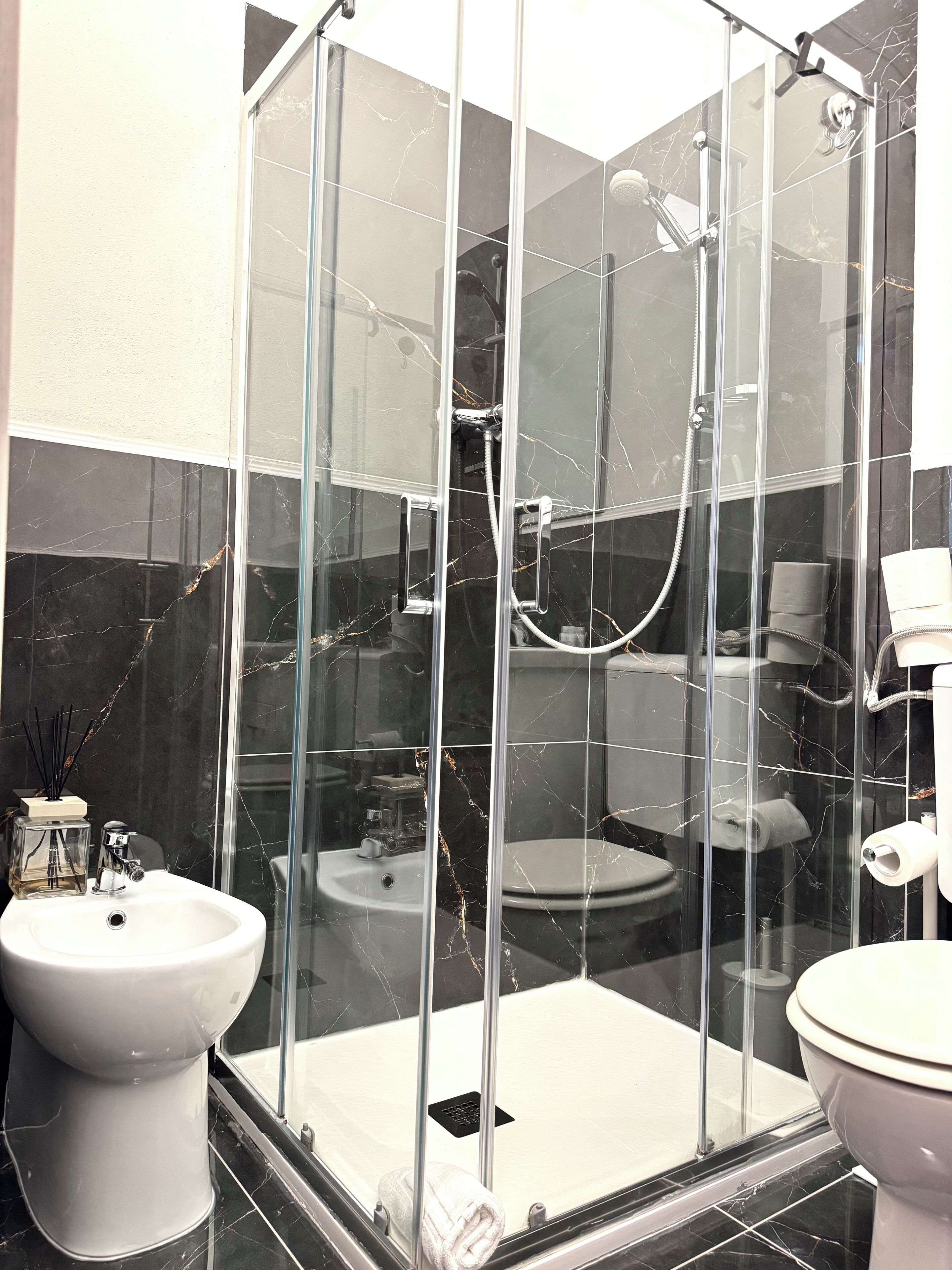Standaard vierpersoonskamer | Badkamer | Een douche, een regendouche, gratis toiletartikelen, een haardroger