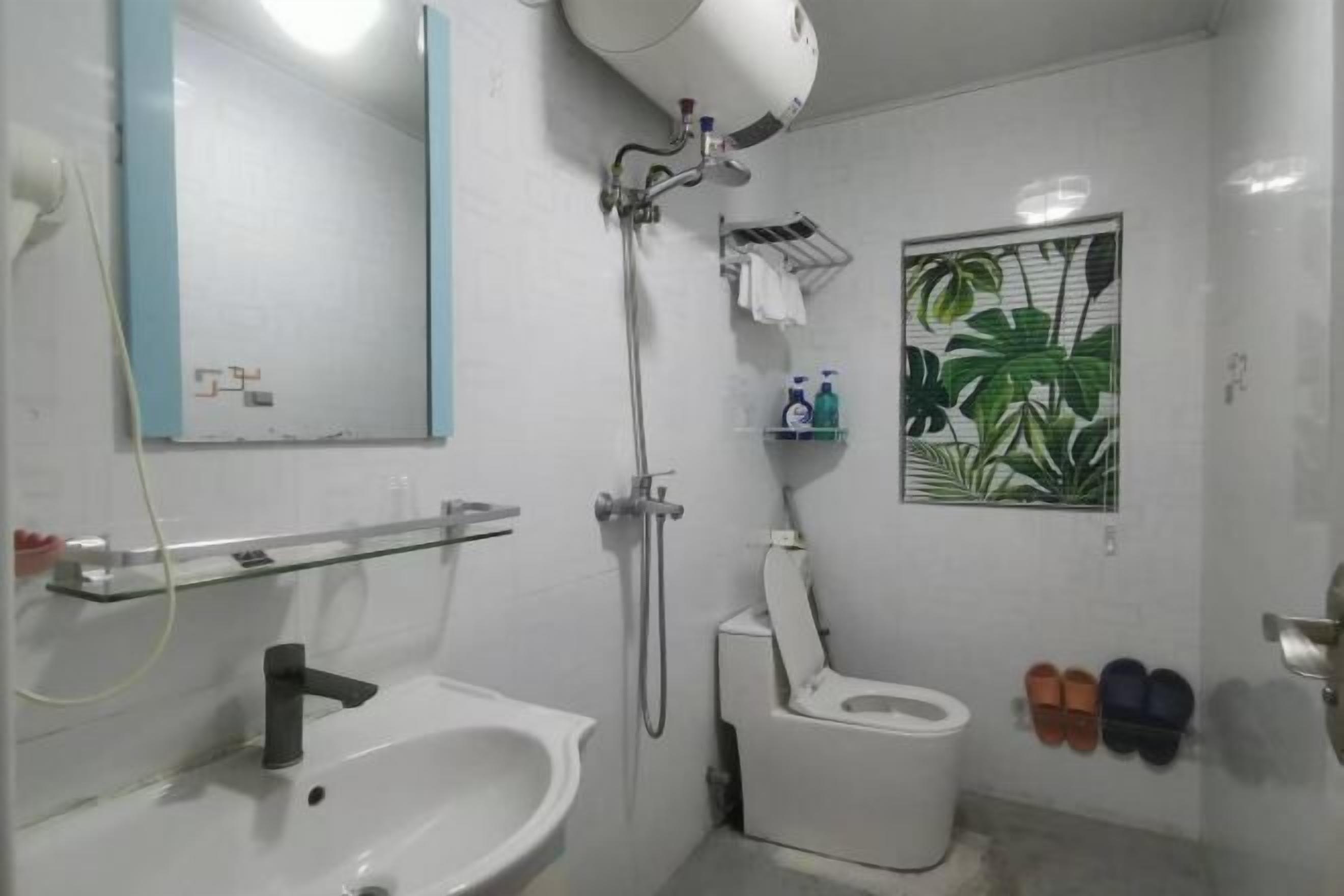 Un baño con lavabo, inodoro, ducha y espejo.