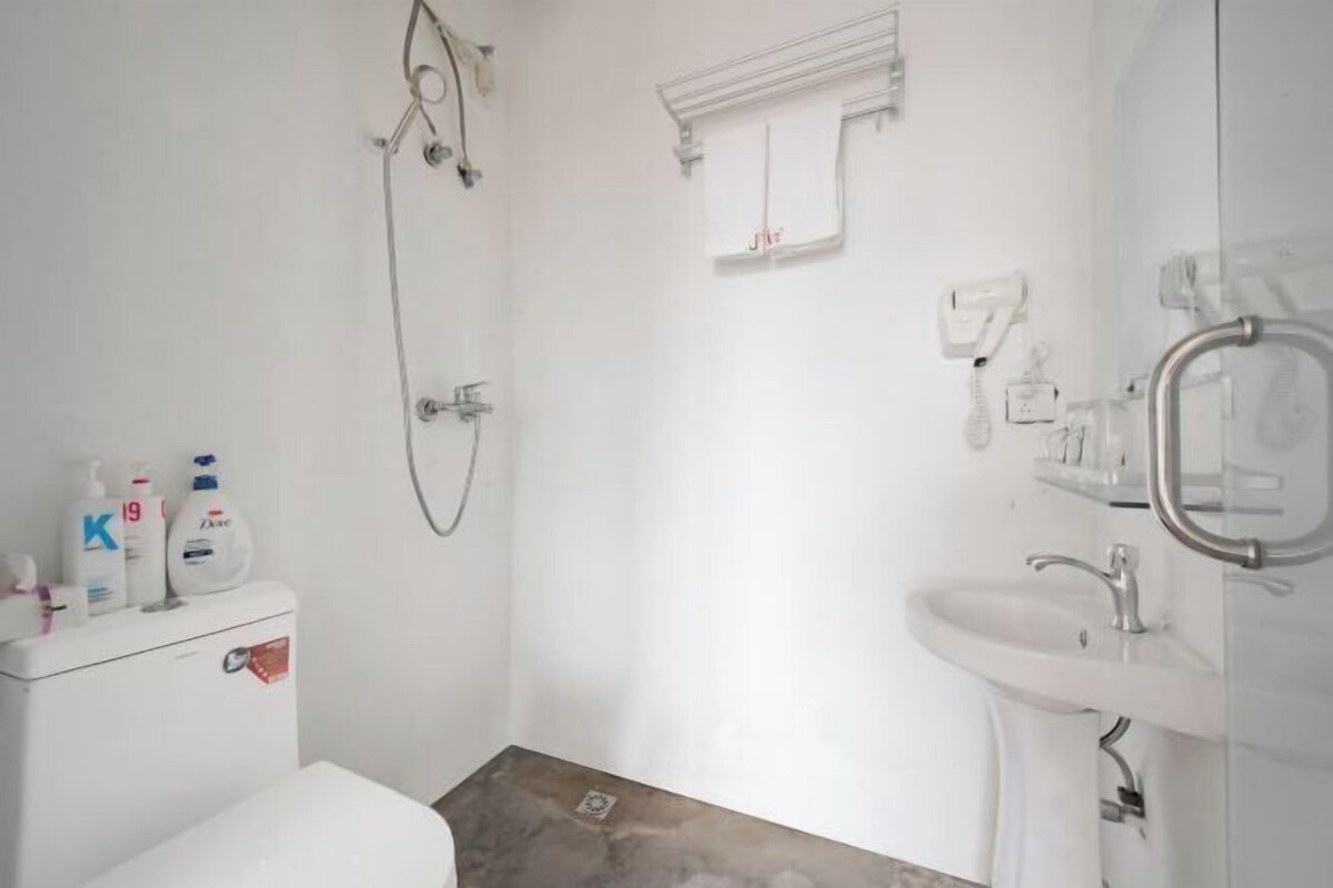 A bathroom with a toilet, shower, and sink.