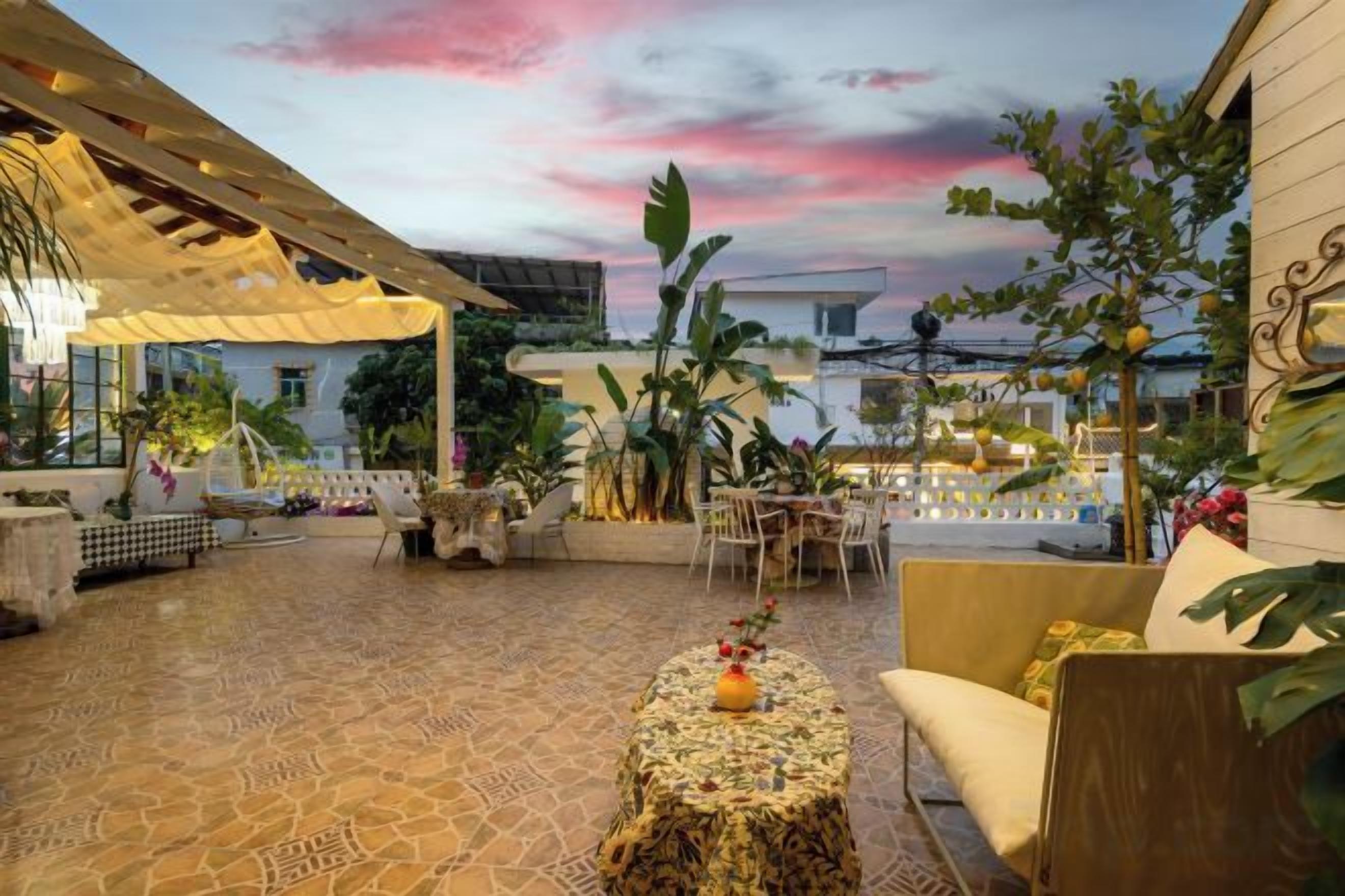 Une terrasse extérieure dotée d’un sol à motifs, d’un espace aménagé avec des sièges et d’une table décorative.