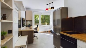 Una cocina moderna con horno empotrado, encimera de madera y un amplio ventanal que proporciona luz natural.