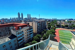 A high-rise building with multiple floors, a sports field, and a clear blue sky. - Jinjiang Inn Select Hotel (Tianjin Tanggu Subway Station Zhongxin North Road) (Tianjin)
