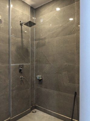 Een douche, handdoeken, zeep, shampoo