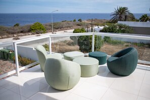 Un balcón con mobiliario moderno y vista al mar.