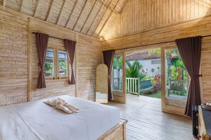 Una habitación de madera con una cama, un ventanal y vistas a un jardín.