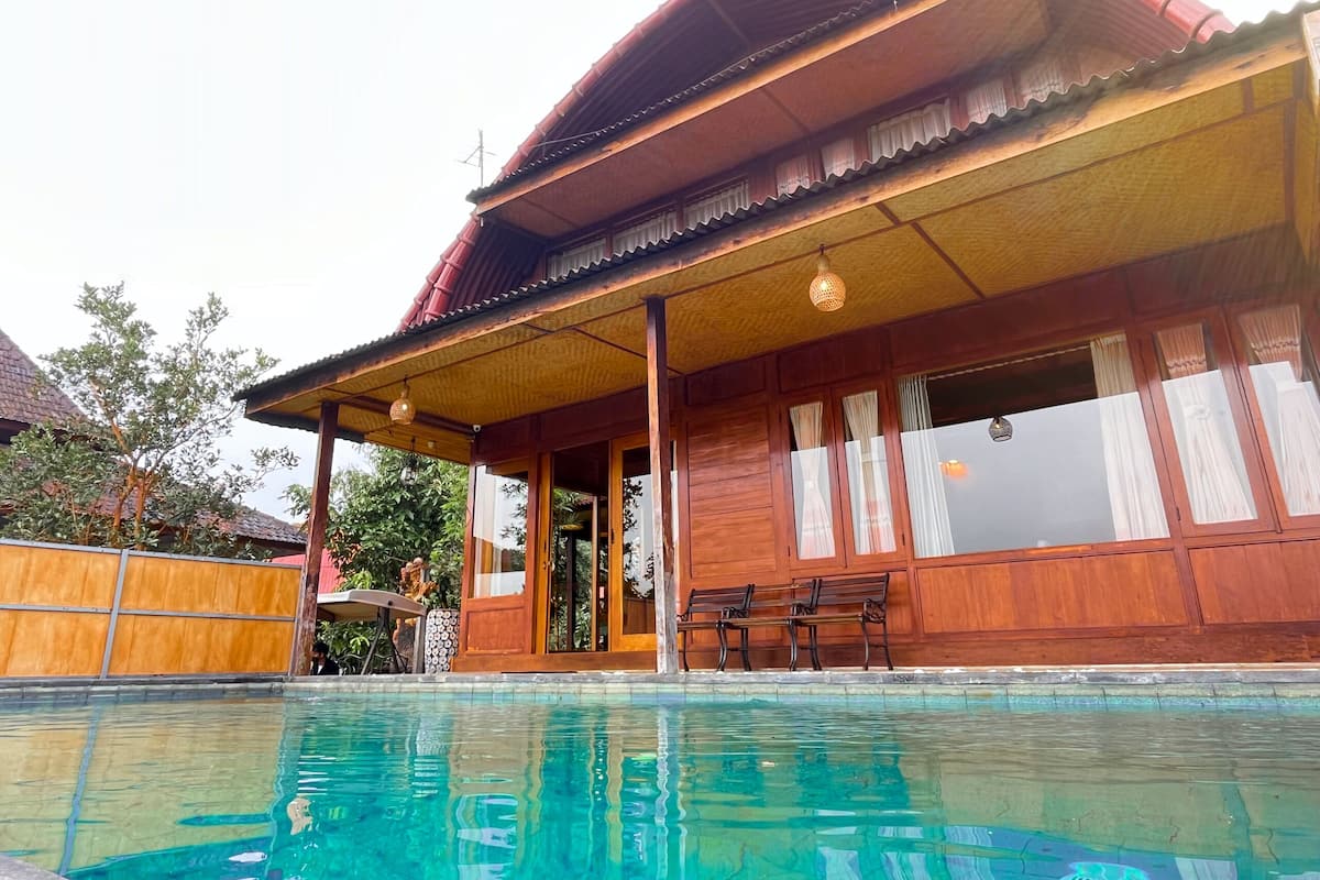 Una casa de madera con piscina delantera.