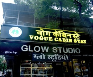 A building with a sign for 'Vogue Cabin Stay' and 'Glow Studio'. - Vogue Cabin Stay Near NESCO (Mumbai)