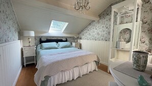 A bedroom with a bed, a nightstand, a dresser, a chandelier, and a skylight. - Jade room (Rosières)