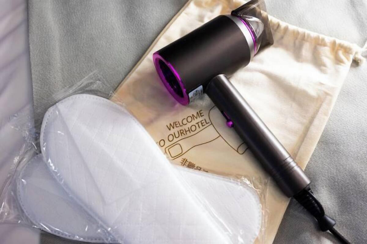 Una plancha para el pelo, una mascarilla facial blanca y un cartel de bienvenida a nuestro hotel.