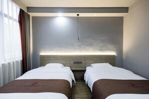 A hotel room with two beds, a wooden headboard, a bedside table, and a window with curtains. - Mitian Business Motel (Ningbo)