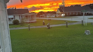 A grassy area with a building and a church in the background. - Historic Harkers Island Bungalow (Harkers Island)