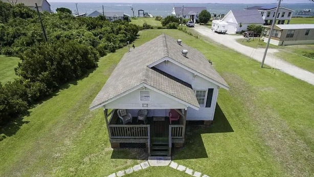 A single-story house with a porch, a small deck, and a view of the sea. - Historic Harkers Island Bungalow (Harkers Island)