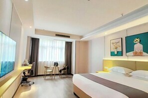 A hotel room with a bed, desk, chairs, and artwork on the walls. - Chongqing Dichen Garden Hotel (Chongqing)