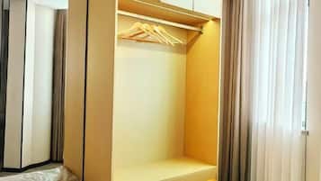 A walk-in closet with a wooden hanger rod and a shelf.