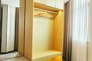 Un armario vestidor con barra de madera y un estante.