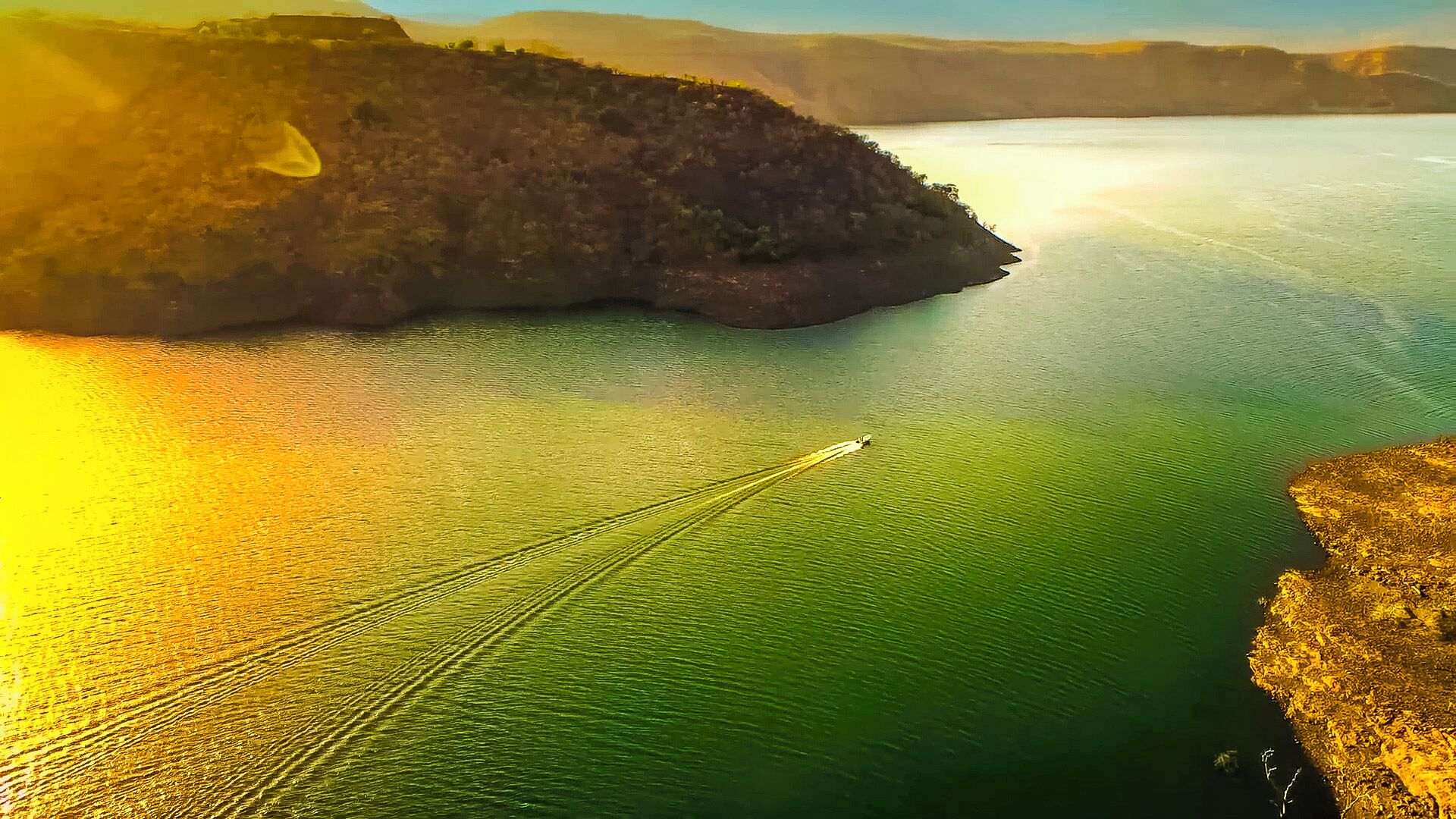Un bote sobre un lago tranquilo con una orilla rocosa.