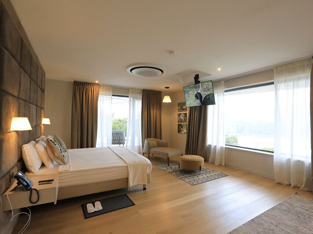 Une chambre d’hôtel moderne équipée d’un grand lit, d’une télévision, d’un bureau et d’une chaise.