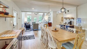 A spacious kitchen with a wooden table and chairs, a built-in oven, and a water dispenser. - Views on 12 Acres: Ozark Mountain Cabin! (Parthenon)