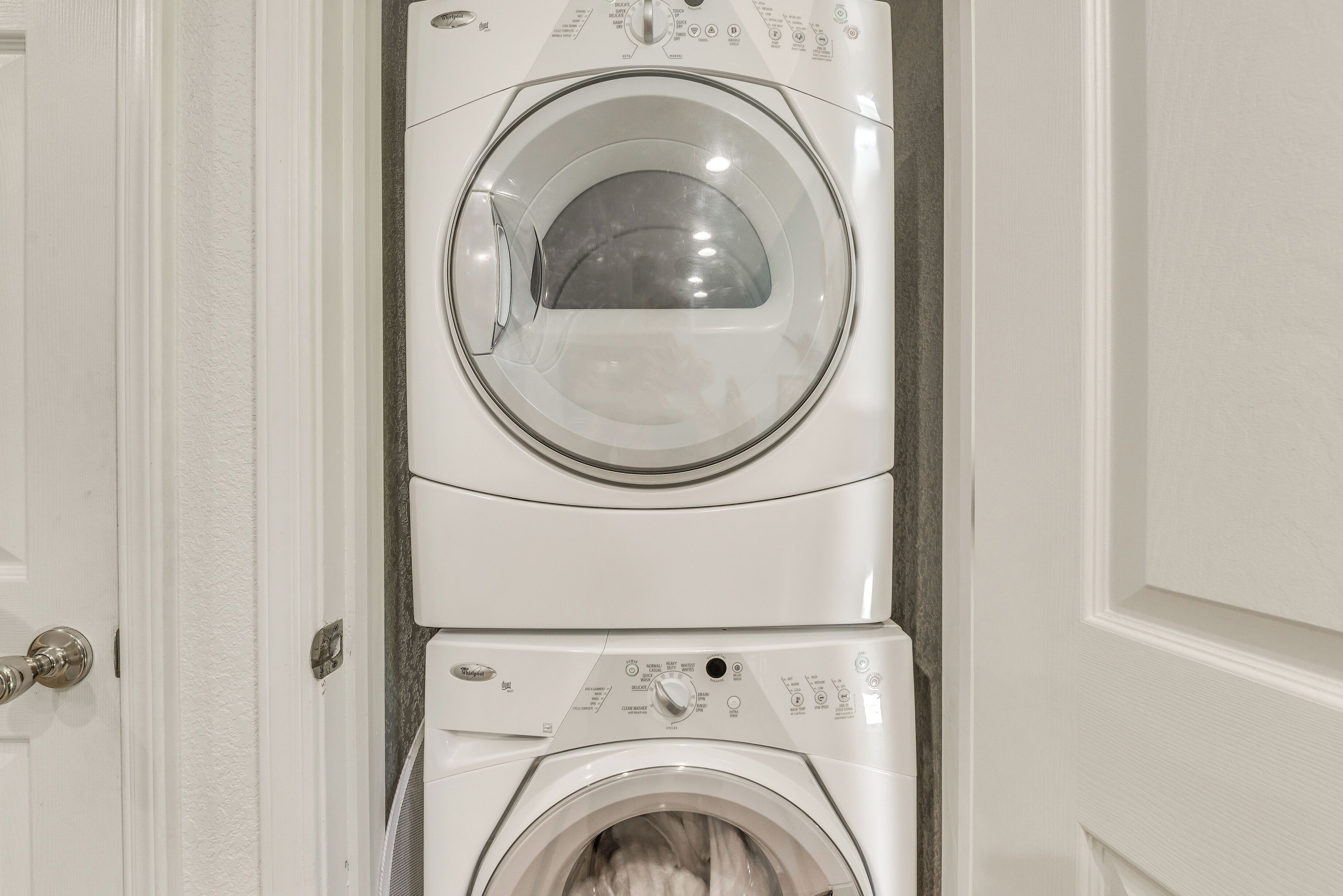 A stacked washer and dryer unit in a bathroom.