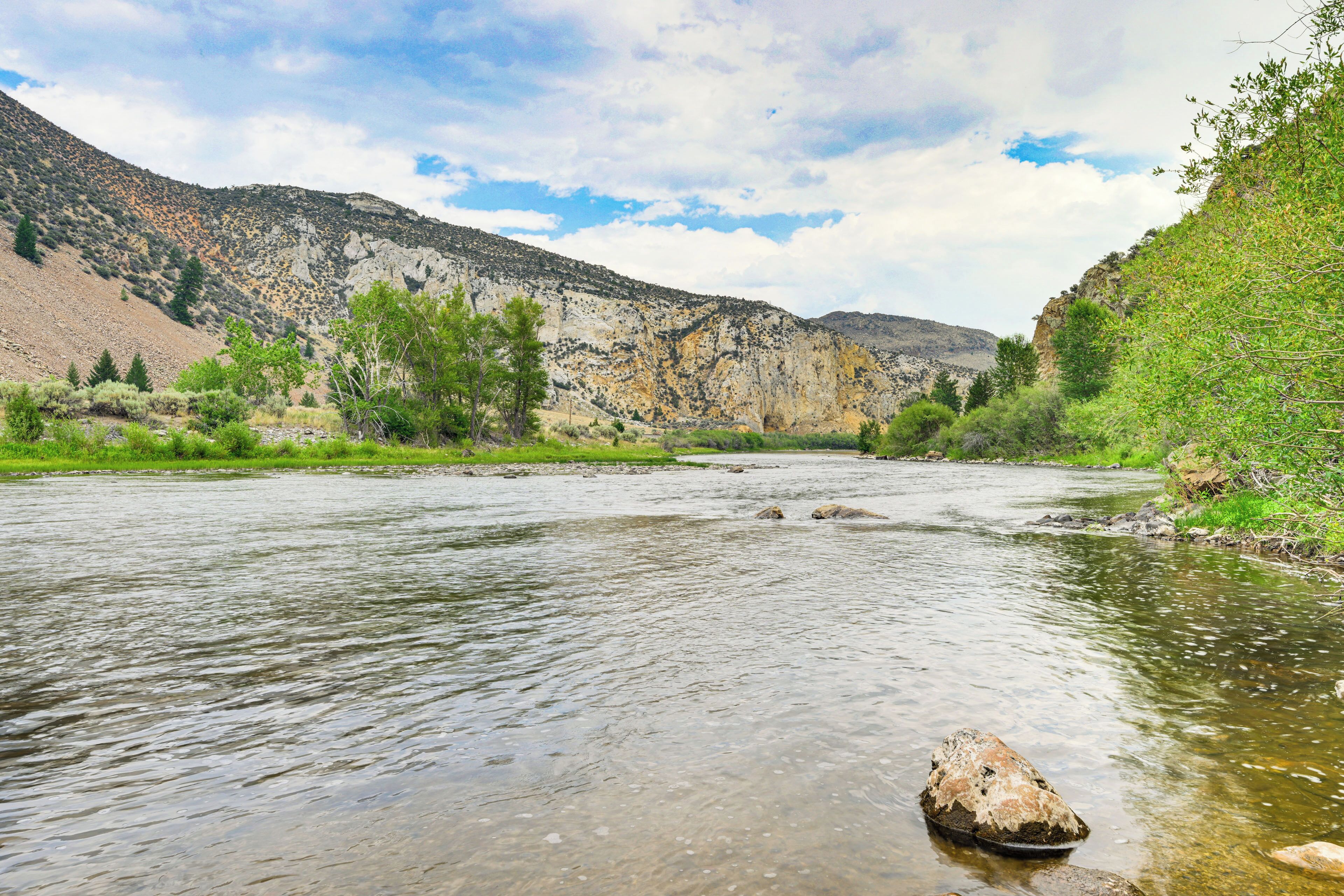 A river flowing through a valley with rocky terrain and sparse vegetation.