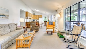 A spacious living room with a sofa, armchairs, and a rocking chair. There is a dining area with a table and chairs, and a kitchen in the background. - Waterfront Wheeler Lake Home w/ Furnished Deck (Athens)