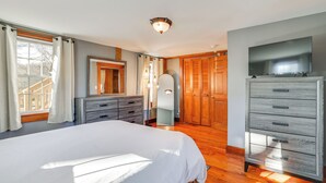 A bedroom with a large bed, wooden wardrobe, and a television on a stand. - Walk to Memorial Park: Pet-friendly Bethlehem Home (Bethlehem)