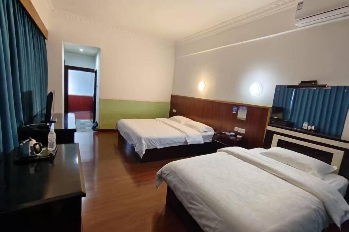 Une chambre d’hôtel avec deux lits, un bureau et un mini-bar.