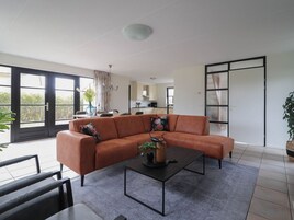 Una sala de estar moderna con un sofá modular, una mesa de centro y vistas a la cocina y al balcón.