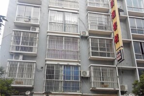 A multi-story building with barred windows and air conditioning units.