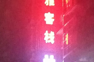 Una señal roja con texto blanco, posiblemente indicando el nombre de un hotel o establecimiento.